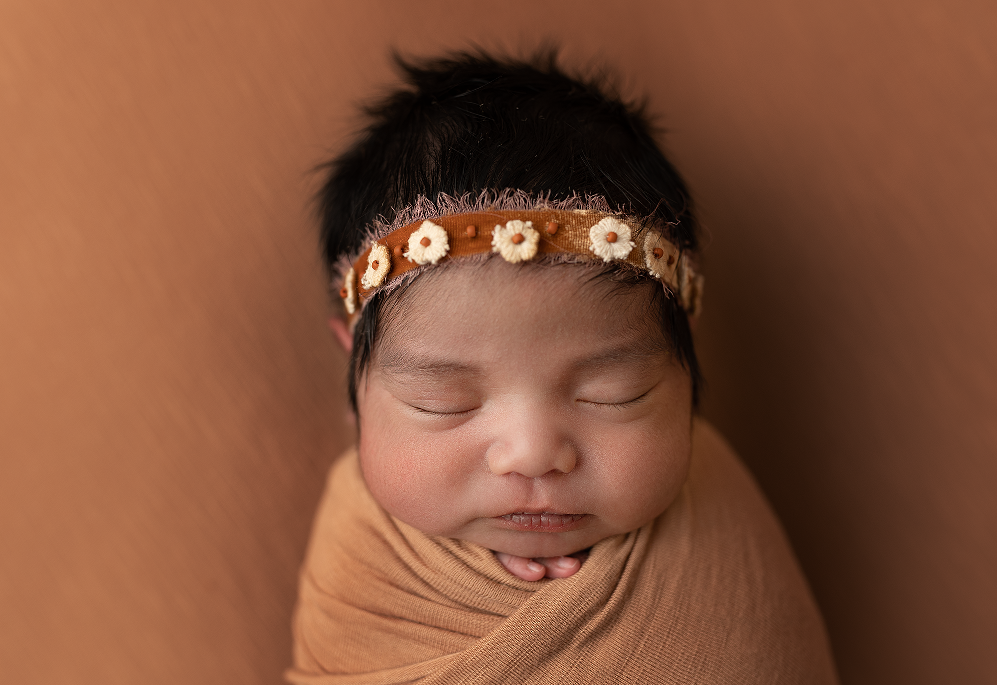 newborn baby girl swaddled and sleeping during newborn photoshoot