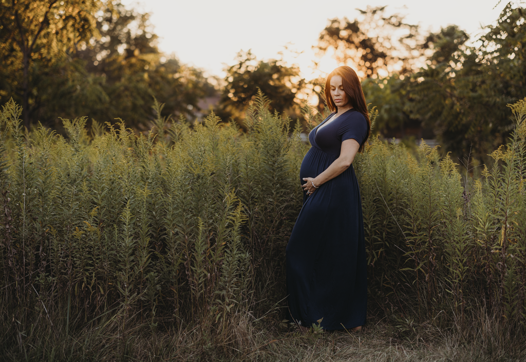 Pregnant mother standing among prairie grasses during a golden hour maternity photography session at Vehe Barn in Deer Park, Illinois.