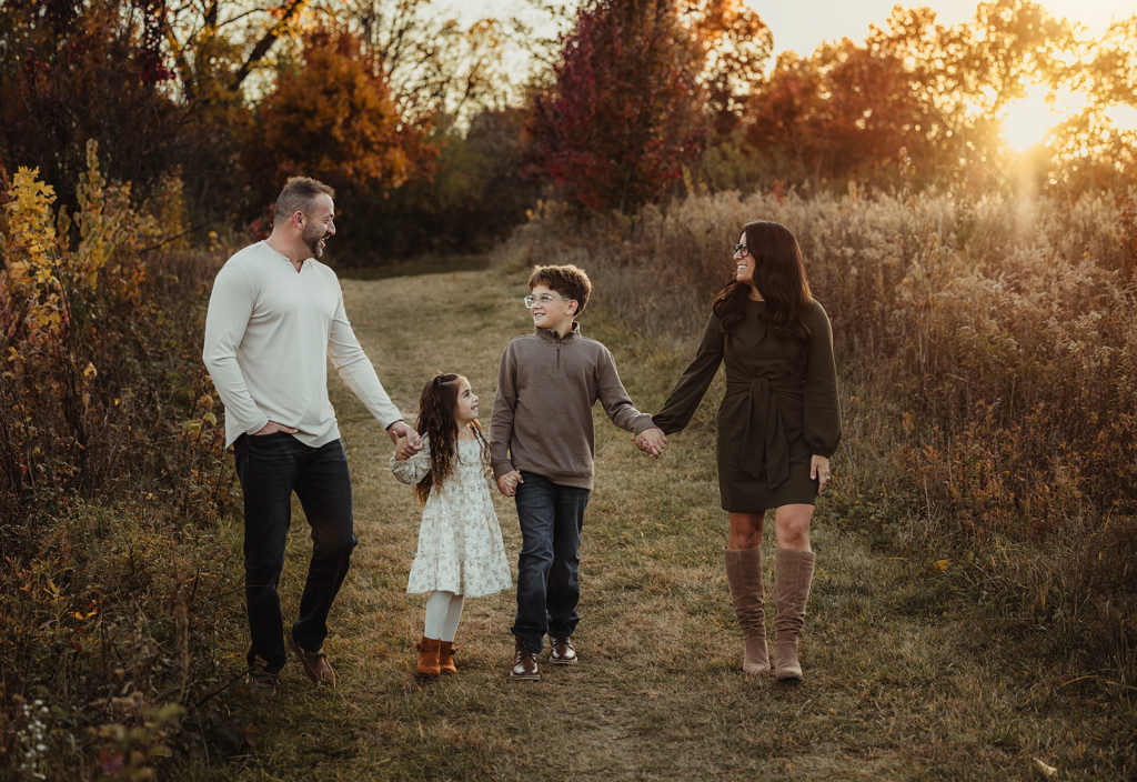 Family walking together during a golden hour family photography session at Schweitzer Woods Forest Preserve in Bartlett, Illinois.