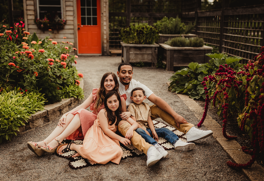 Family of four seated together in a colorful garden courtyard at Cantigny Park in Wheaton, Illinois.