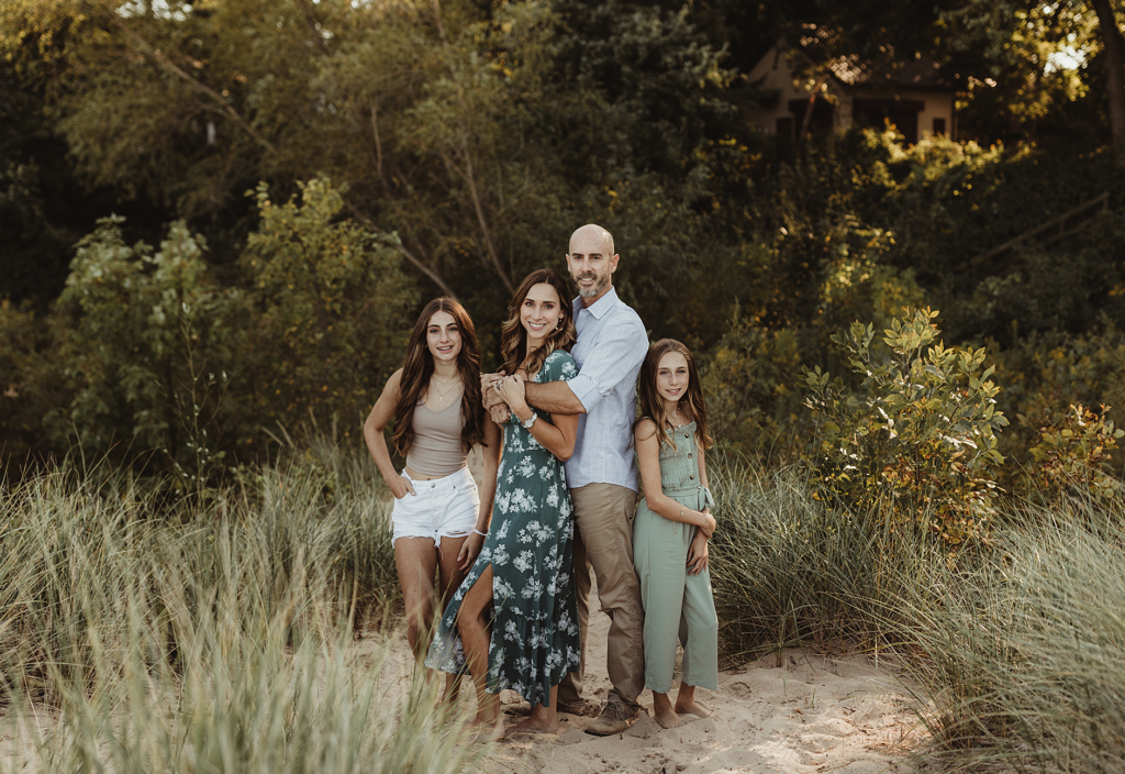 Family standing together among beach grasses at Lighthouse Beach in Evanston, IL.