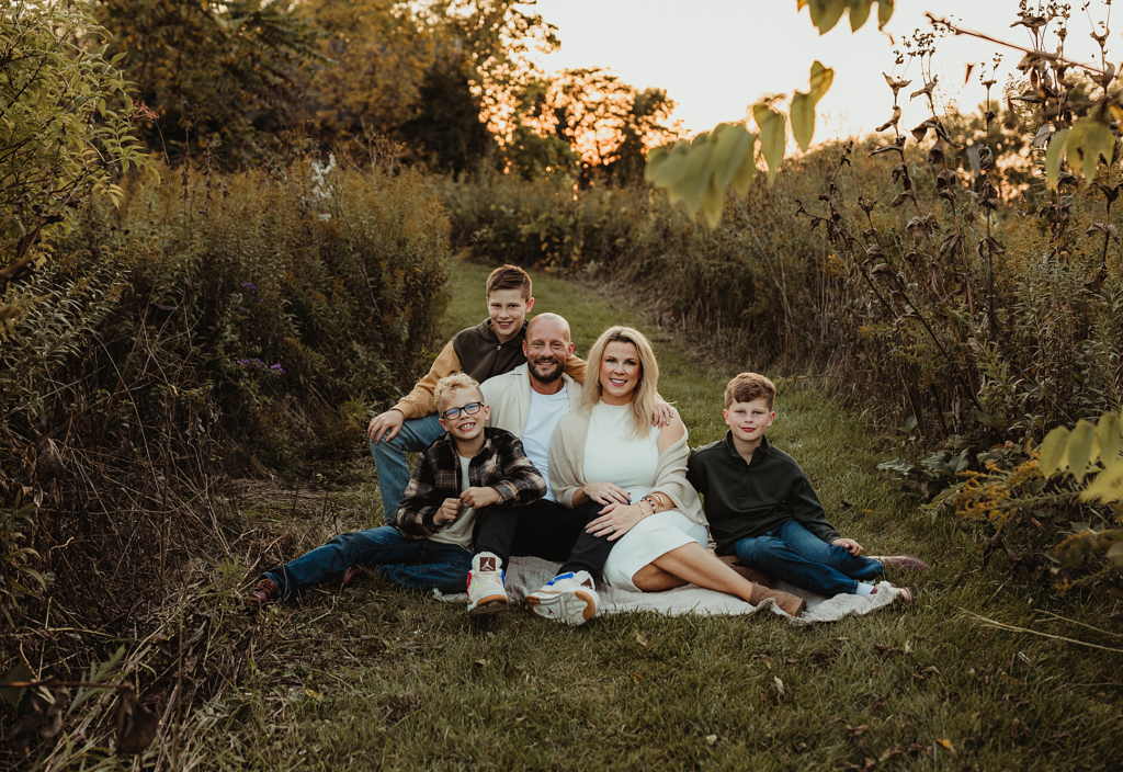 Family sitting together on a blanket during an outdoor session at Vehe Farm Park
