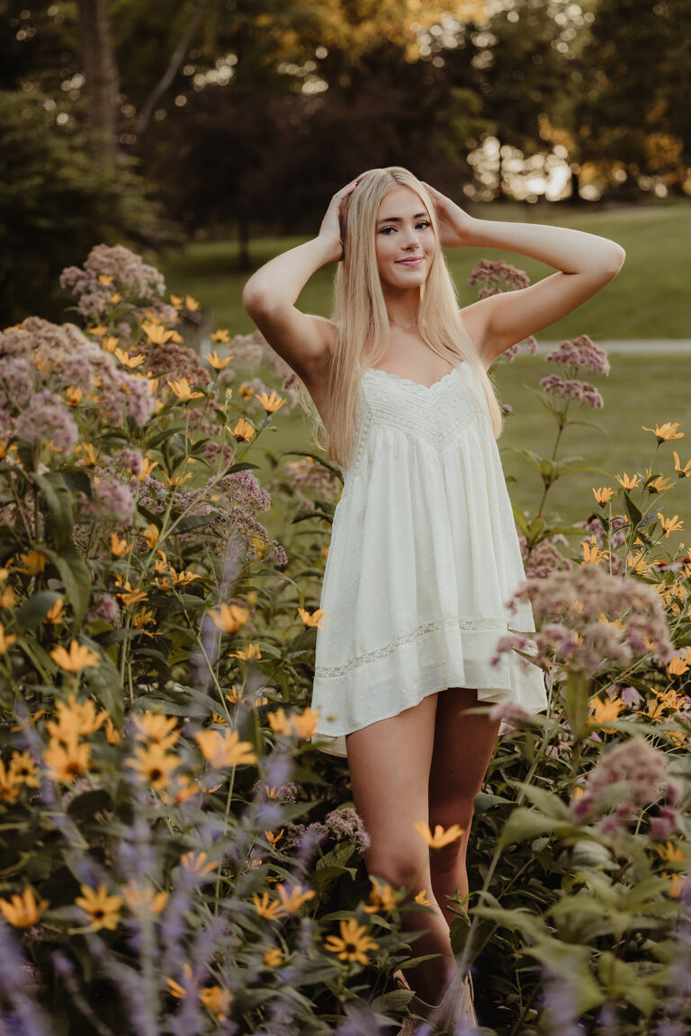 Central High School senior wearing a white dress surrounded by summer wildflowers at Fabyan Forest Preserve