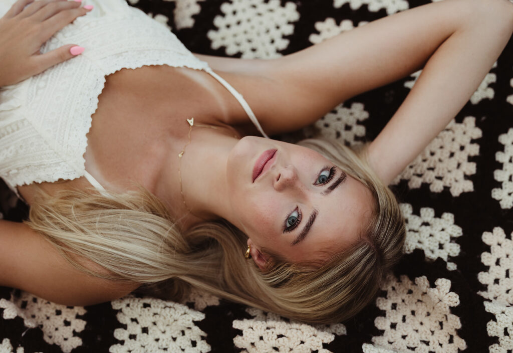 Creative close-up portrait of a Central High School senior lying on a crochet blanket
