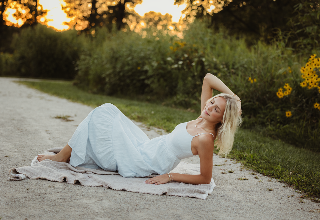 Hampshire High School senior in a light blue dress posing near wildflowers at Leroy Oakes Forest Preserve in St. Charles