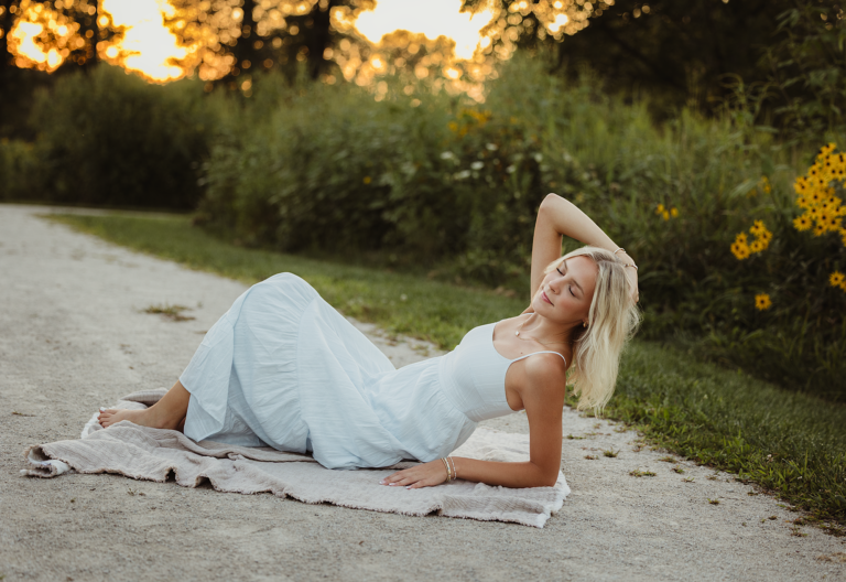 Hampshire High School senior in a light blue dress posing near wildflowers at Leroy Oakes Forest Preserve in St. Charles
