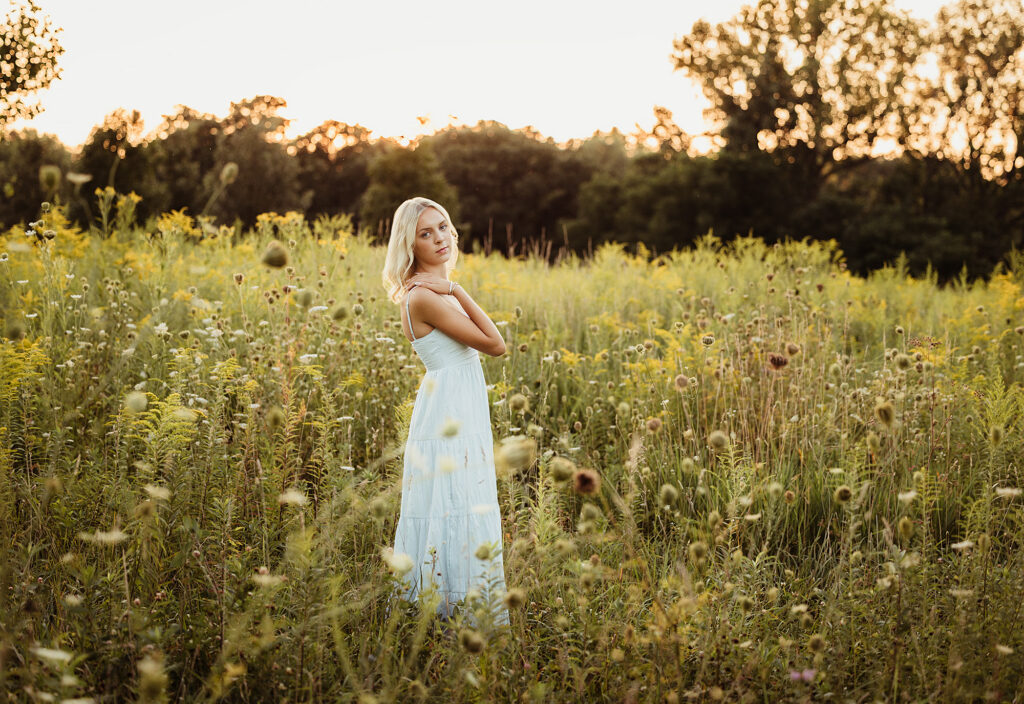 Hampshire High School senior in a light blue dress standing among prairie wildflowers at LeRoy Oakes Forest Preserve