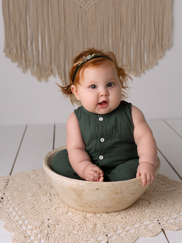 Little Baby Wearing A Green Dress and Sitting