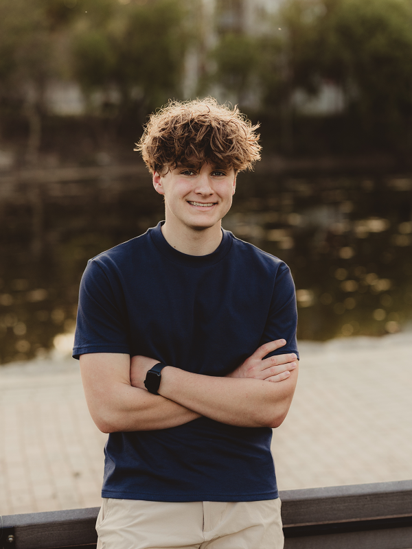 Central High School senior standing by river during photo session in downtown Batavia