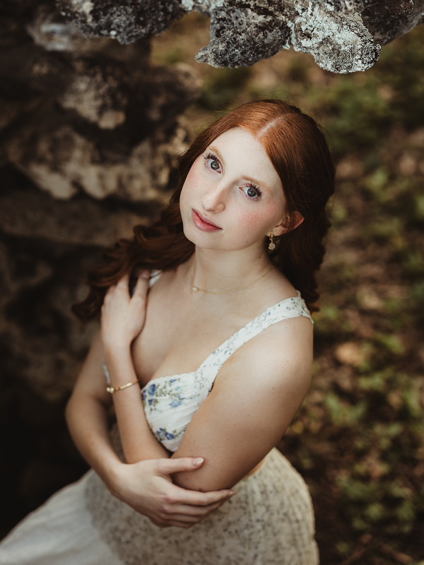 Close-up portrait of a St. Edward Central Catholic High School senior beside the historic stone wall at Fabyan Forest Preserve.
